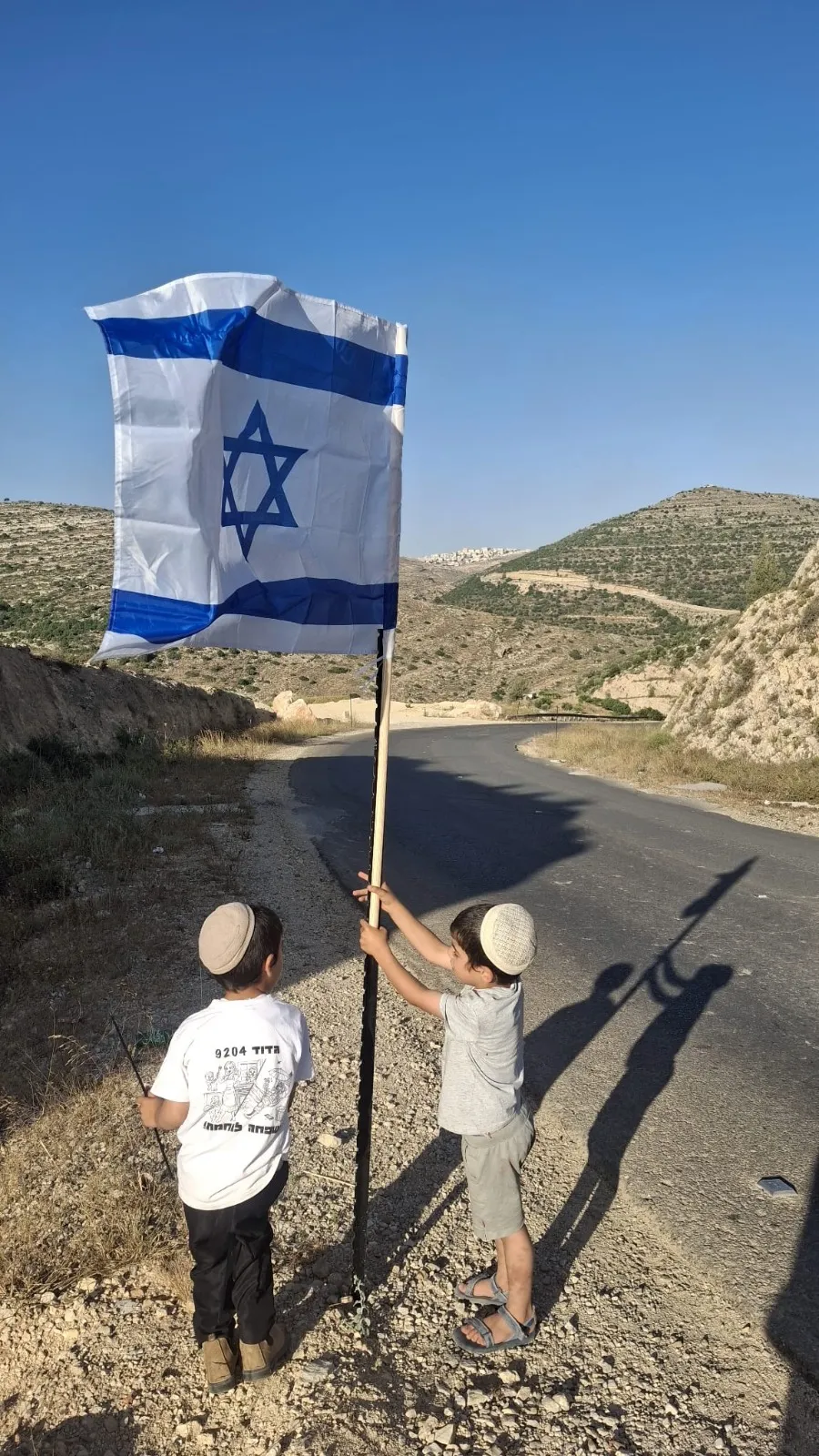 בני נוער תולים את הדגלים בדרך ליישוב מעוז צור 