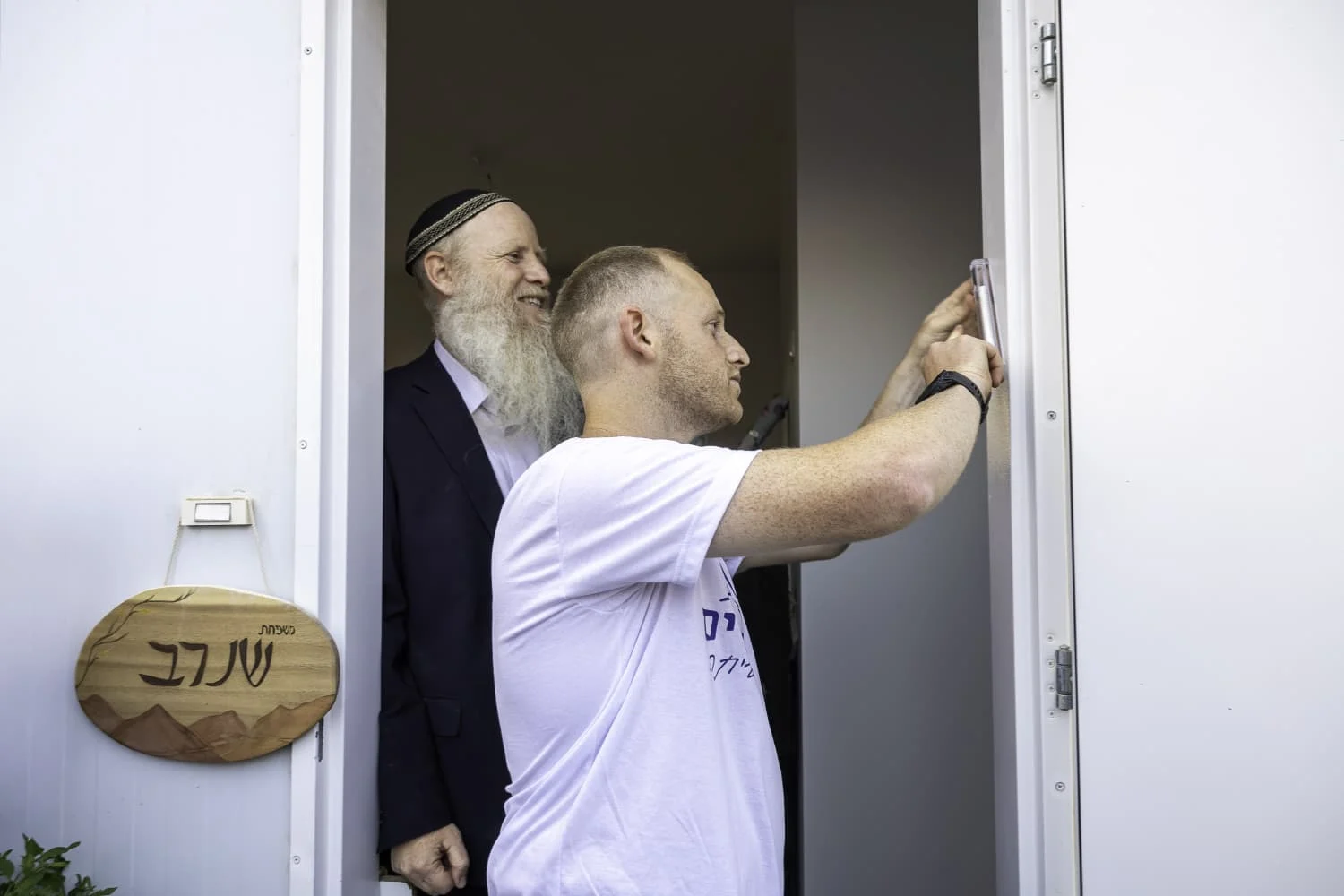 דביר שנרב קובע מזוזה בביתו החדש בנאות הרים ביחד עם אביו הרב איתן שנרב 